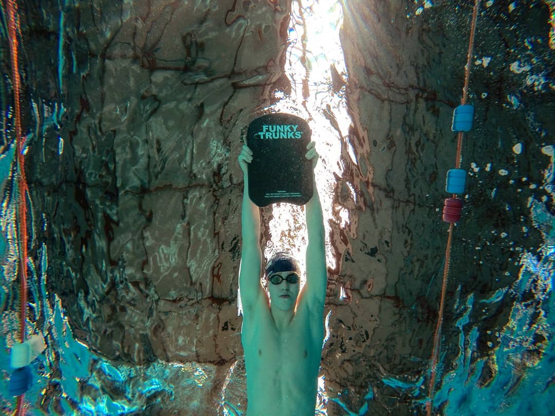 swimmer underwater with kick board