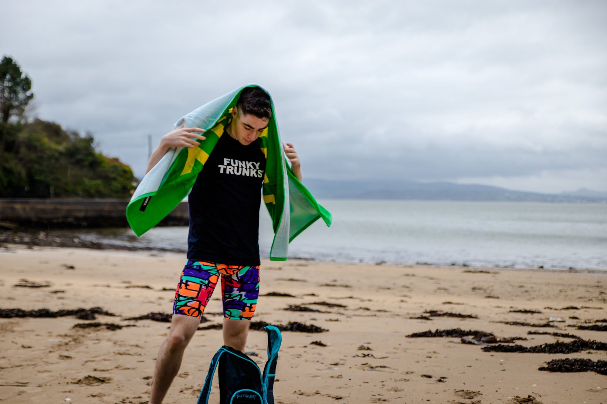 man standing on the beach with towel over his head