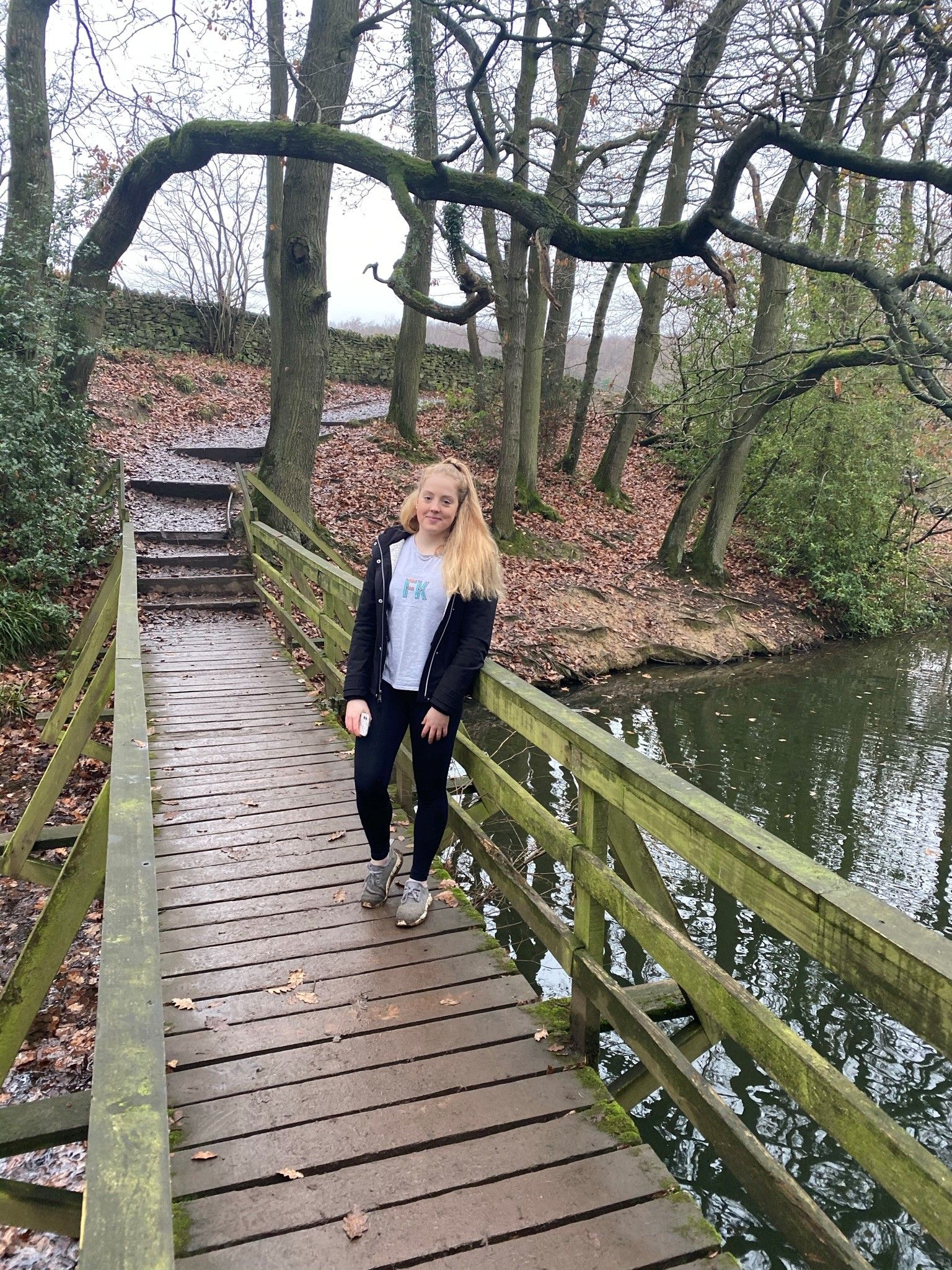 person posing on a bridge on an autumn day