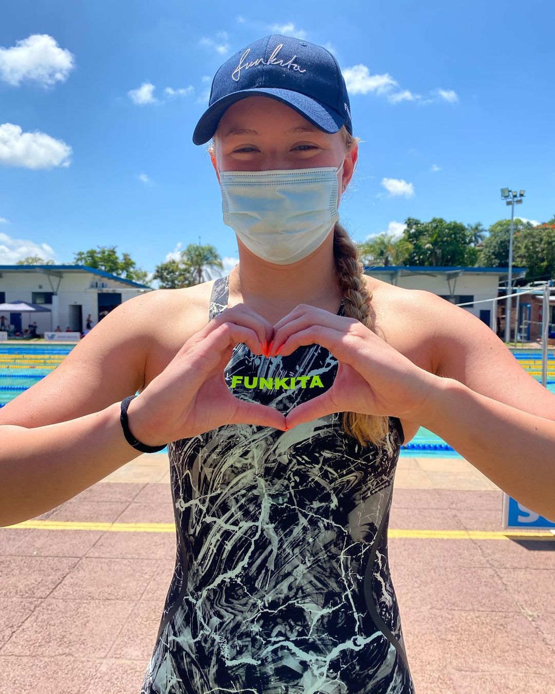 woman makes heart shape with her hands