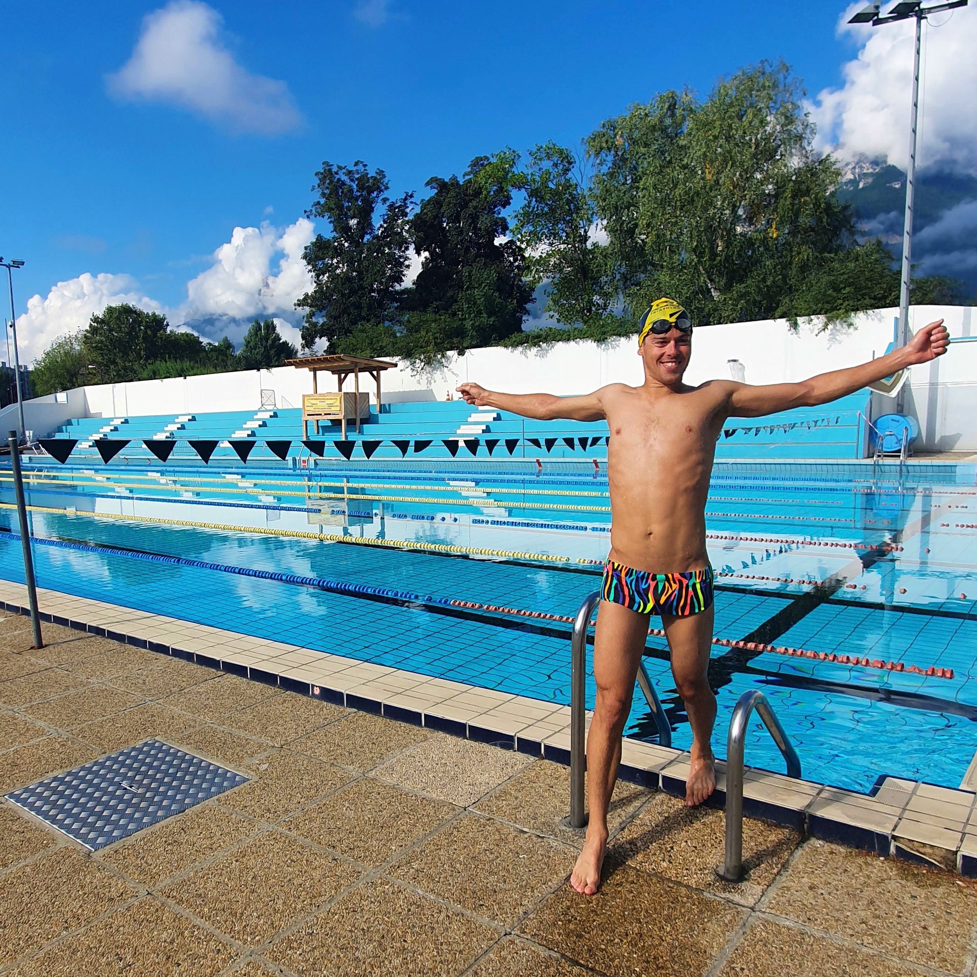 swimmer stepping out of the pool with arms stretched out
