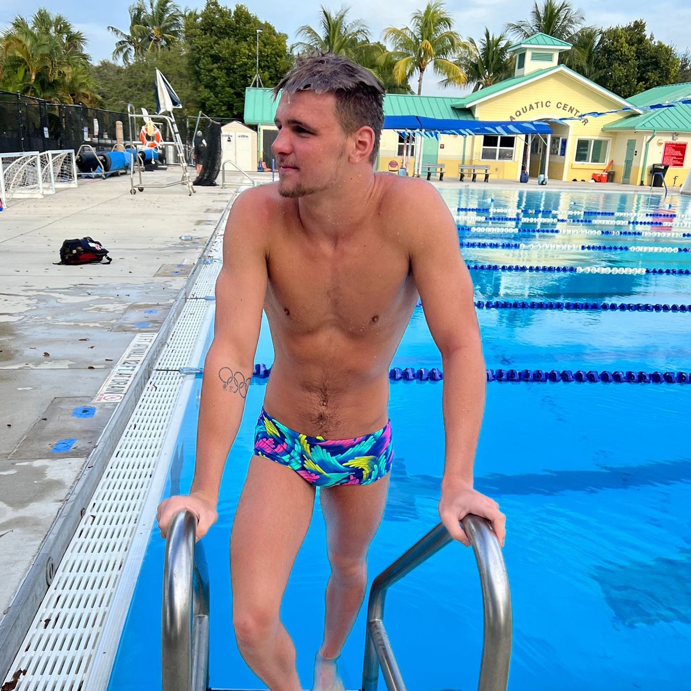 swimmer holding pool ladder coming out of pool