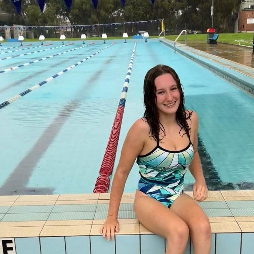swimmer siting on edge of pool
